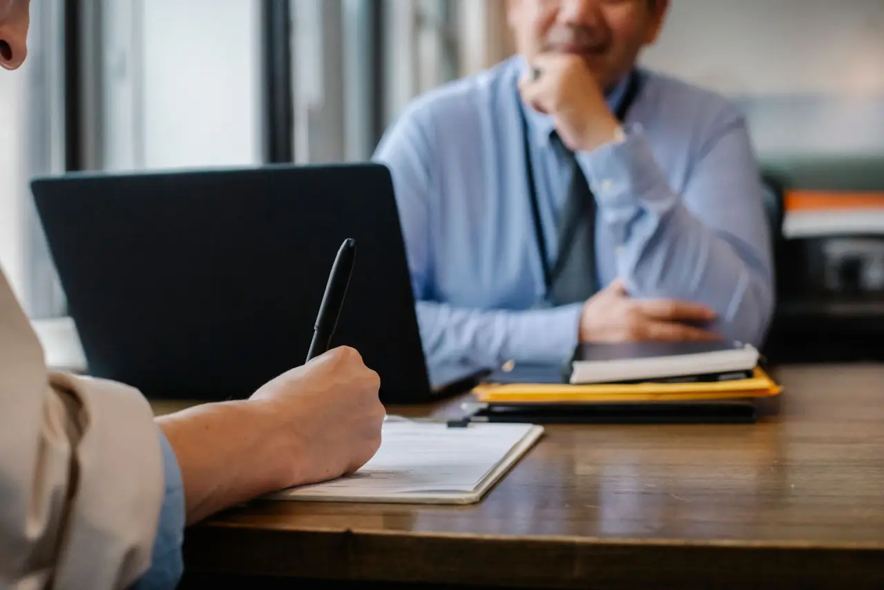 Personne remplissant des documents au bureau pendant un entretien