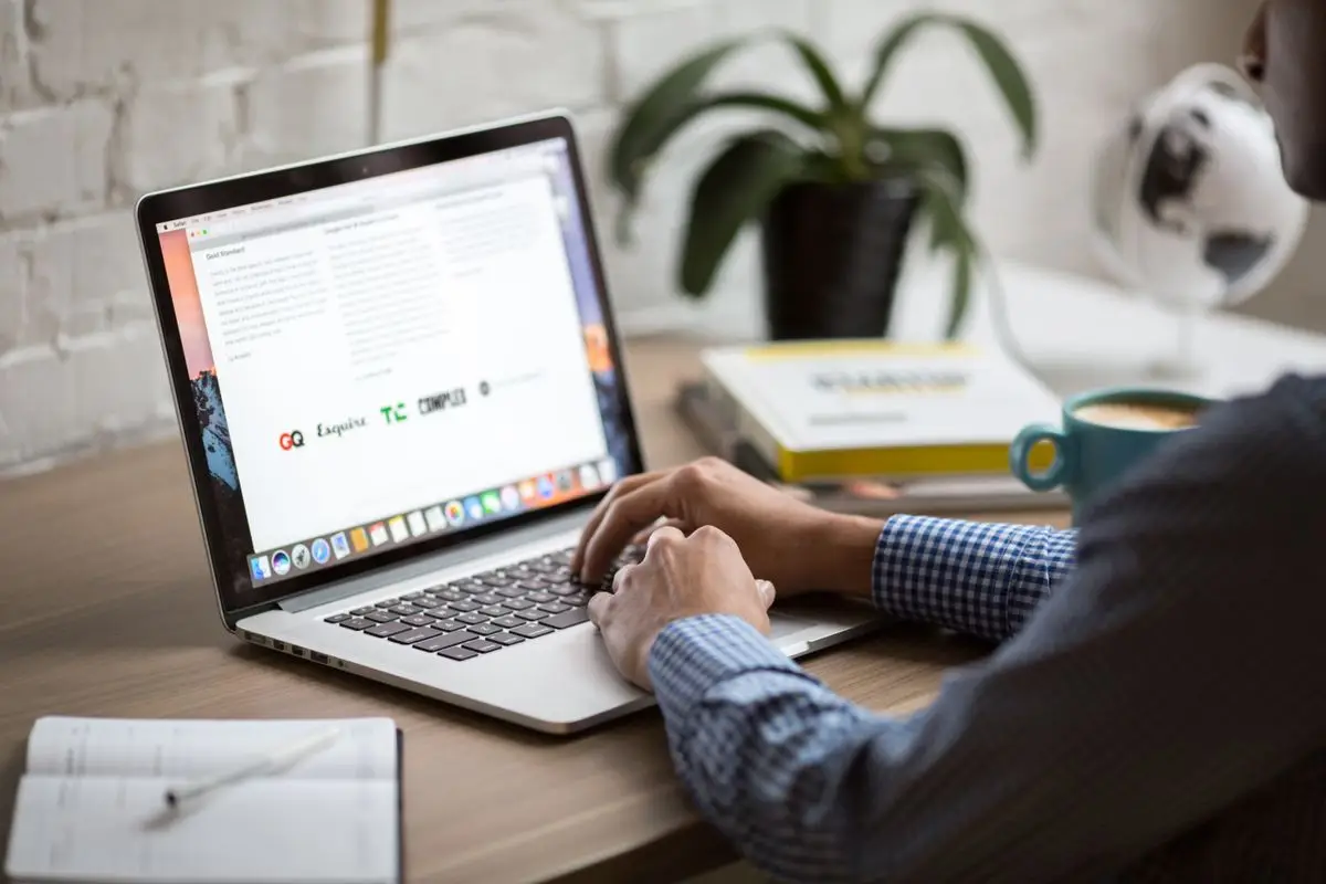 Personne au bureau avec un ordinateur portable et un carnet